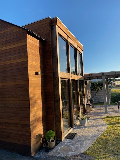 Timber-clad building with glazing and pergola